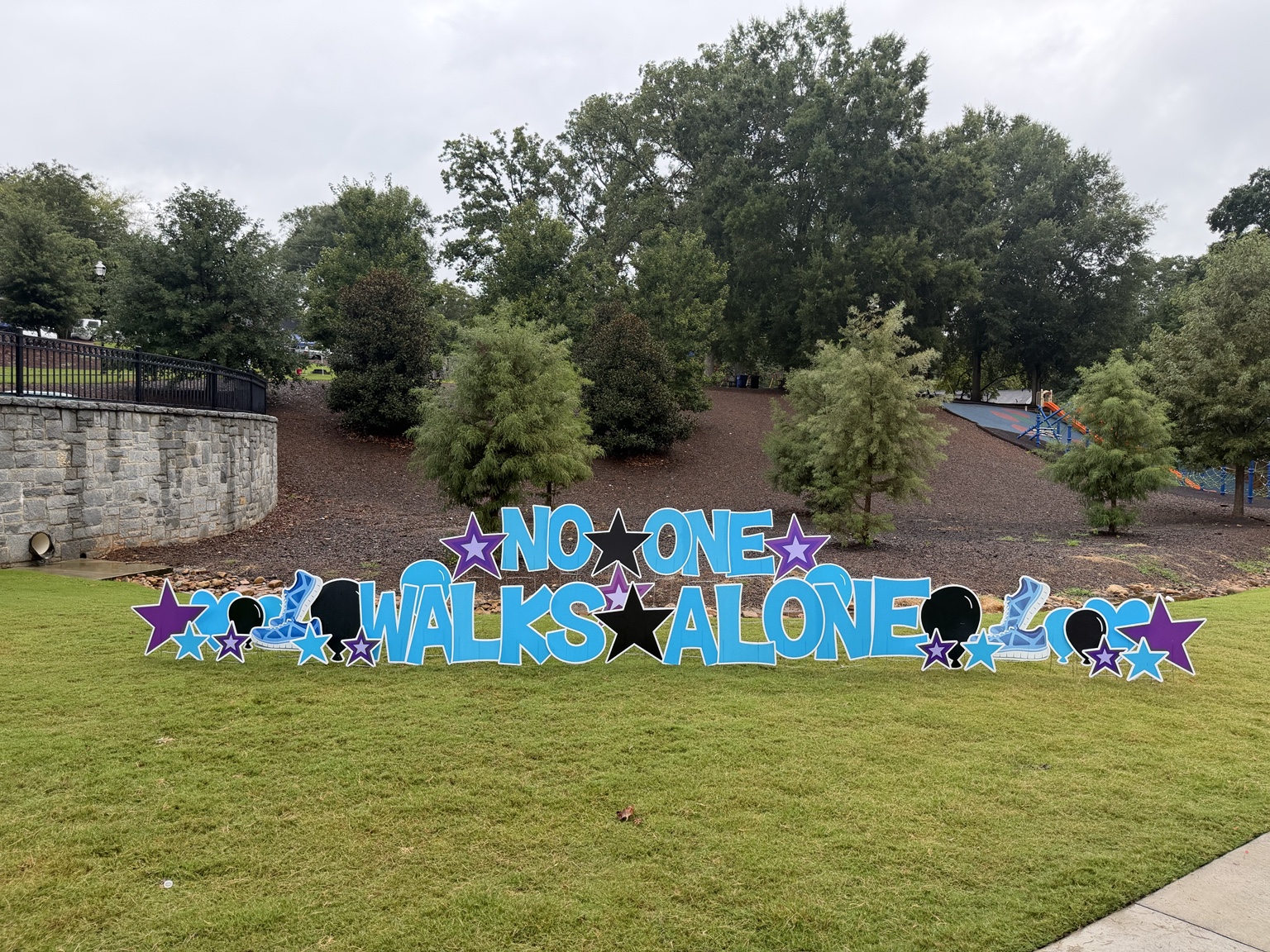 No One Walks Alone suicide prevention event sign at C.J. Smith Park in Newnan, Georgia.